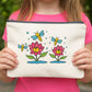 Person holding a pouch with bee and flower design