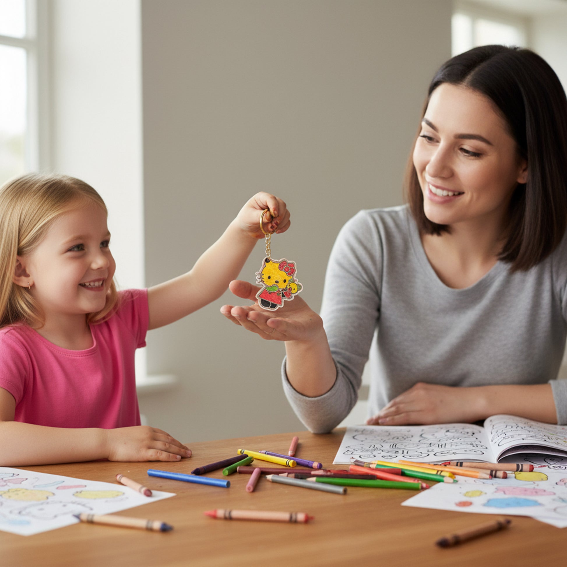 Woman and child sitting at a table with coloring supplies, holding a small toy together.