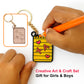 Hand holding a keychain with a small notebook charm, labeled 'Creative Art & Craft Set Gift for Girls & Boys'.